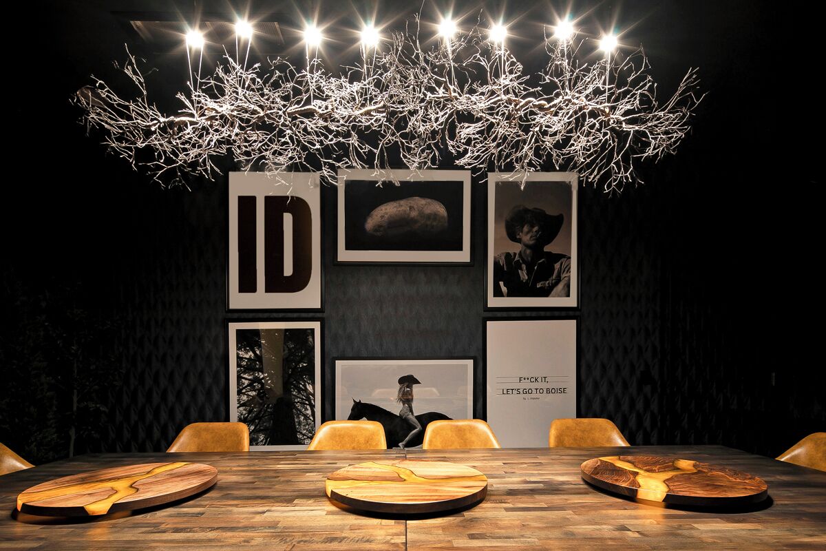 A modern dining area with a wooden table, chairs, and a unique chandelier.