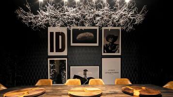 A modern dining area with a wooden table, chairs, and a unique chandelier.