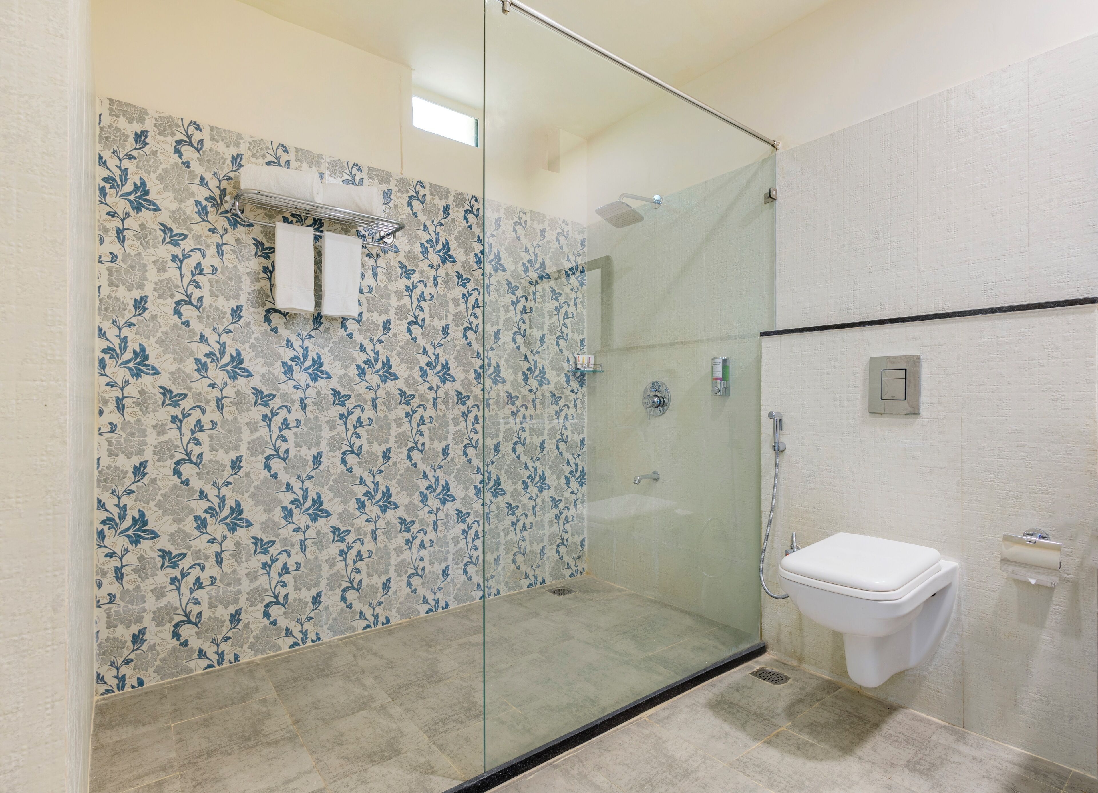 A modern bathroom with a glass shower enclosure, a toilet, and a sink.