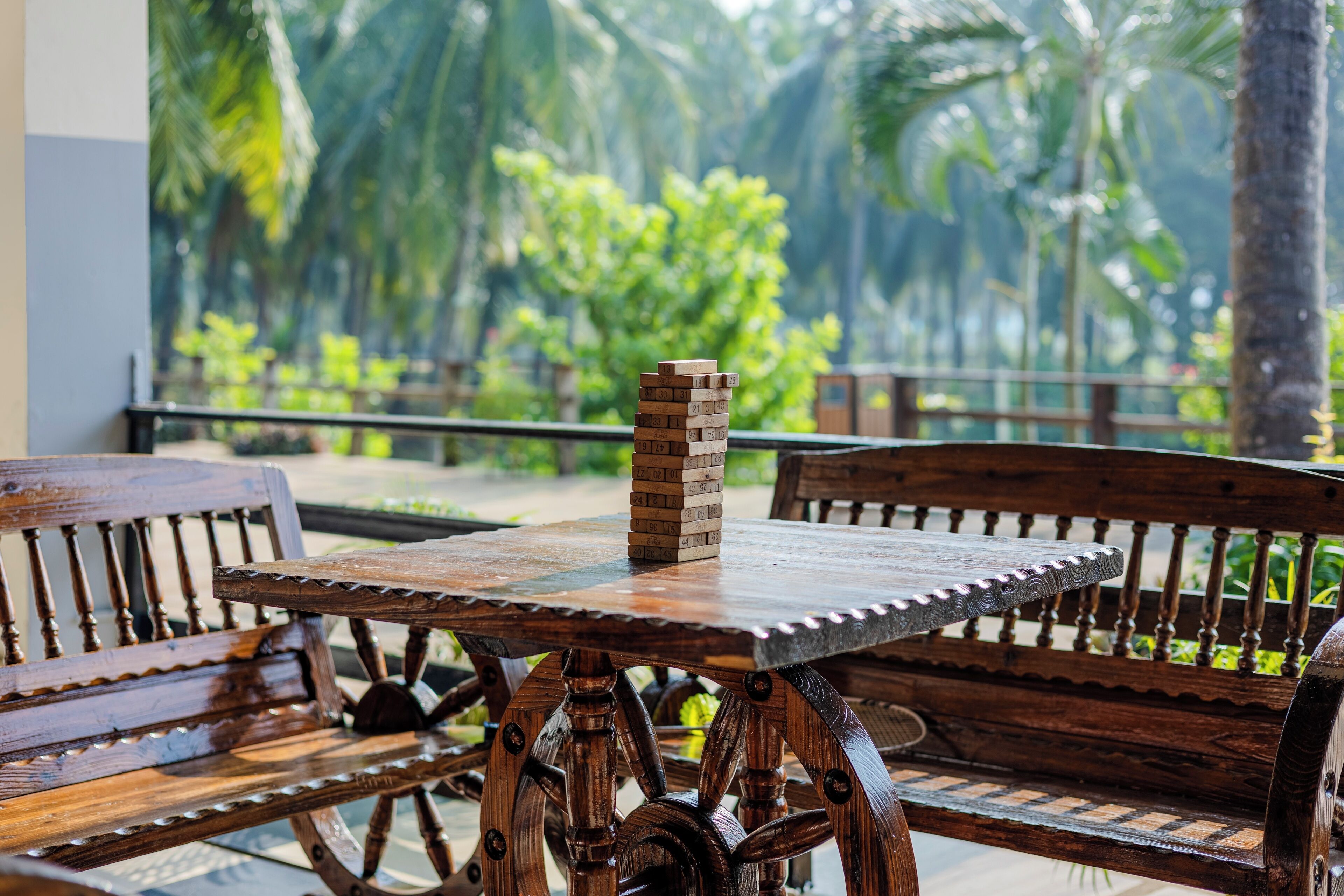 A wooden bench and table set outdoors with a stack of bricks on the table.