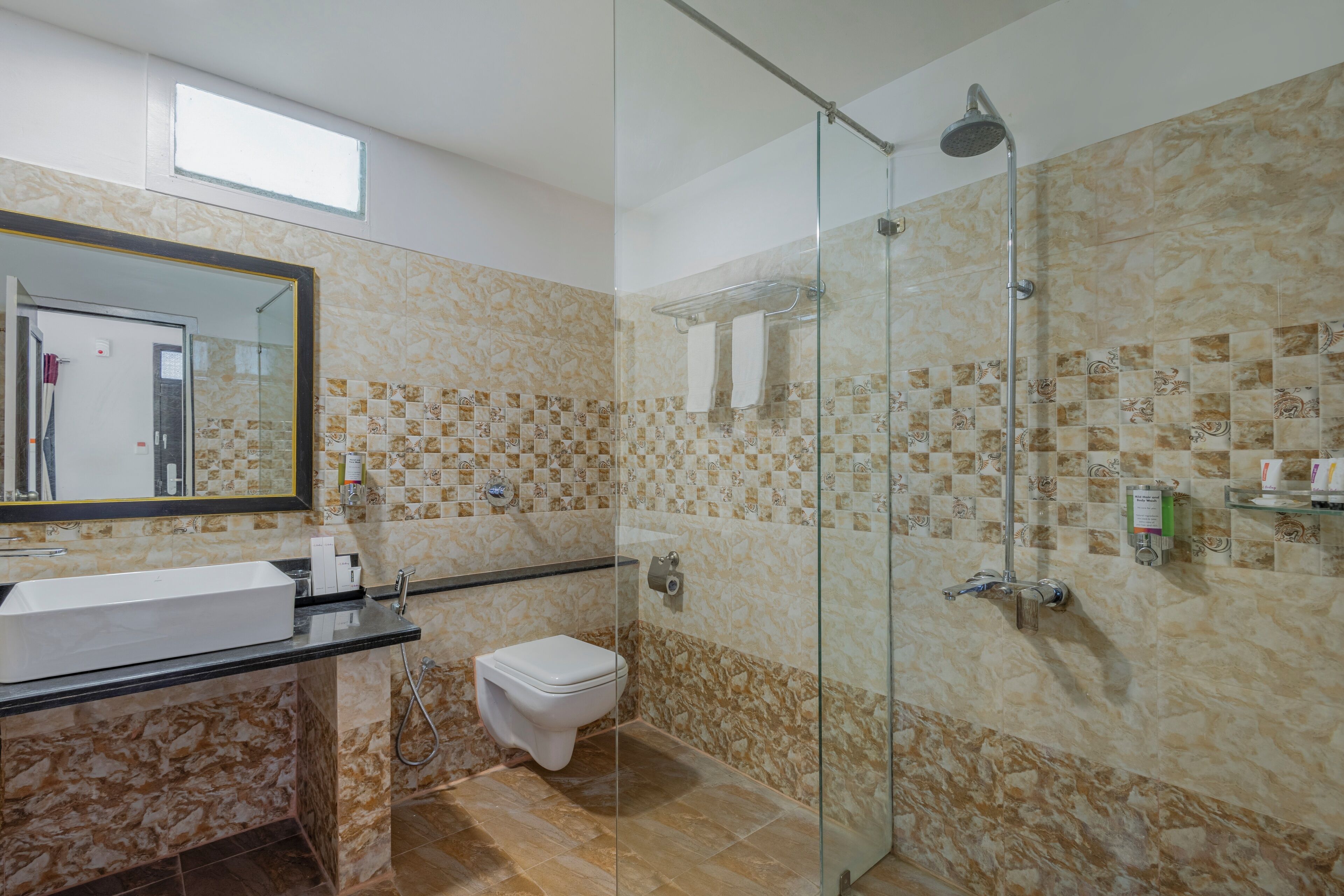 A bathroom with a glass-enclosed shower, a white sink, and a toilet.