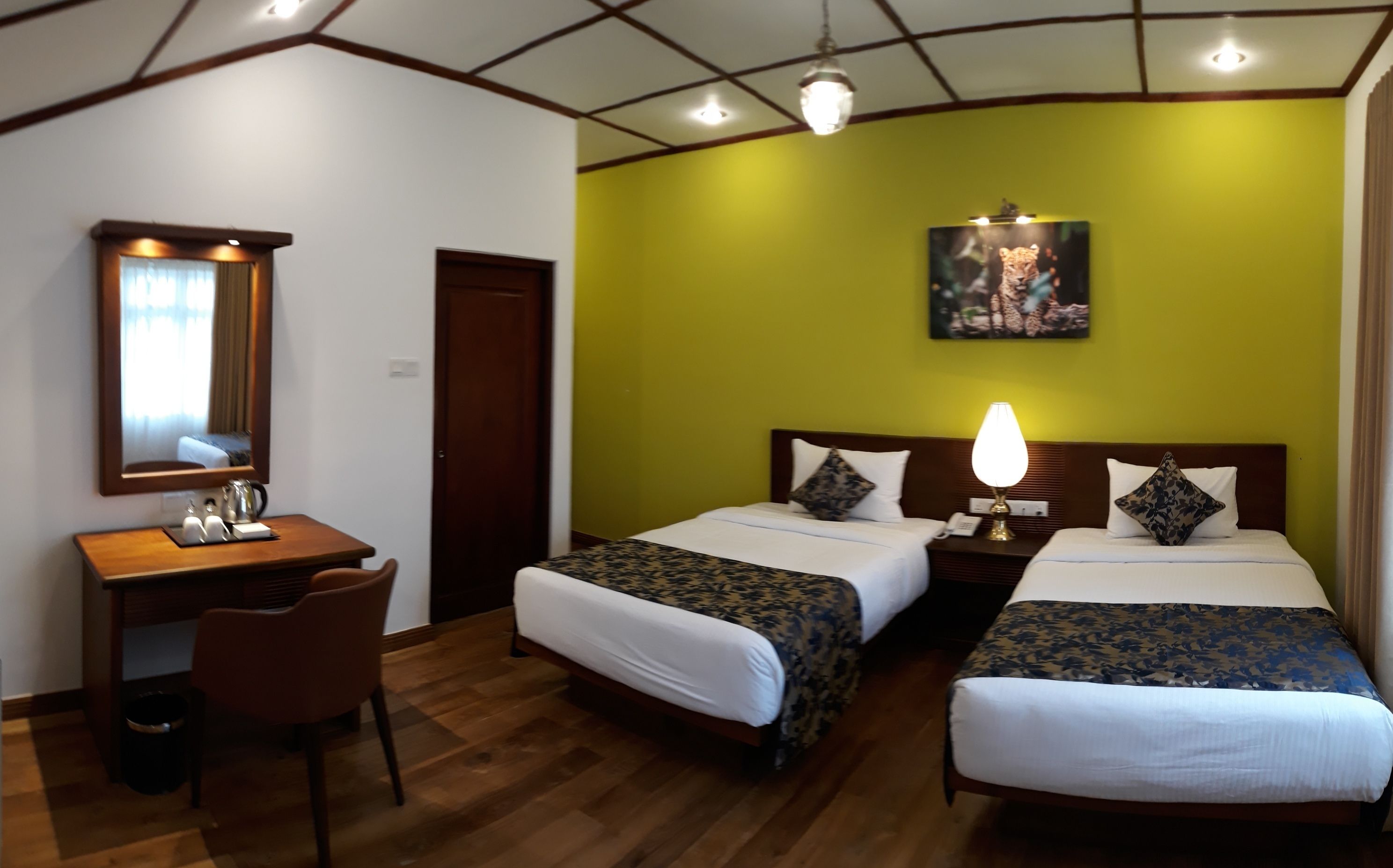 A hotel room with two beds, a desk, and a chair.