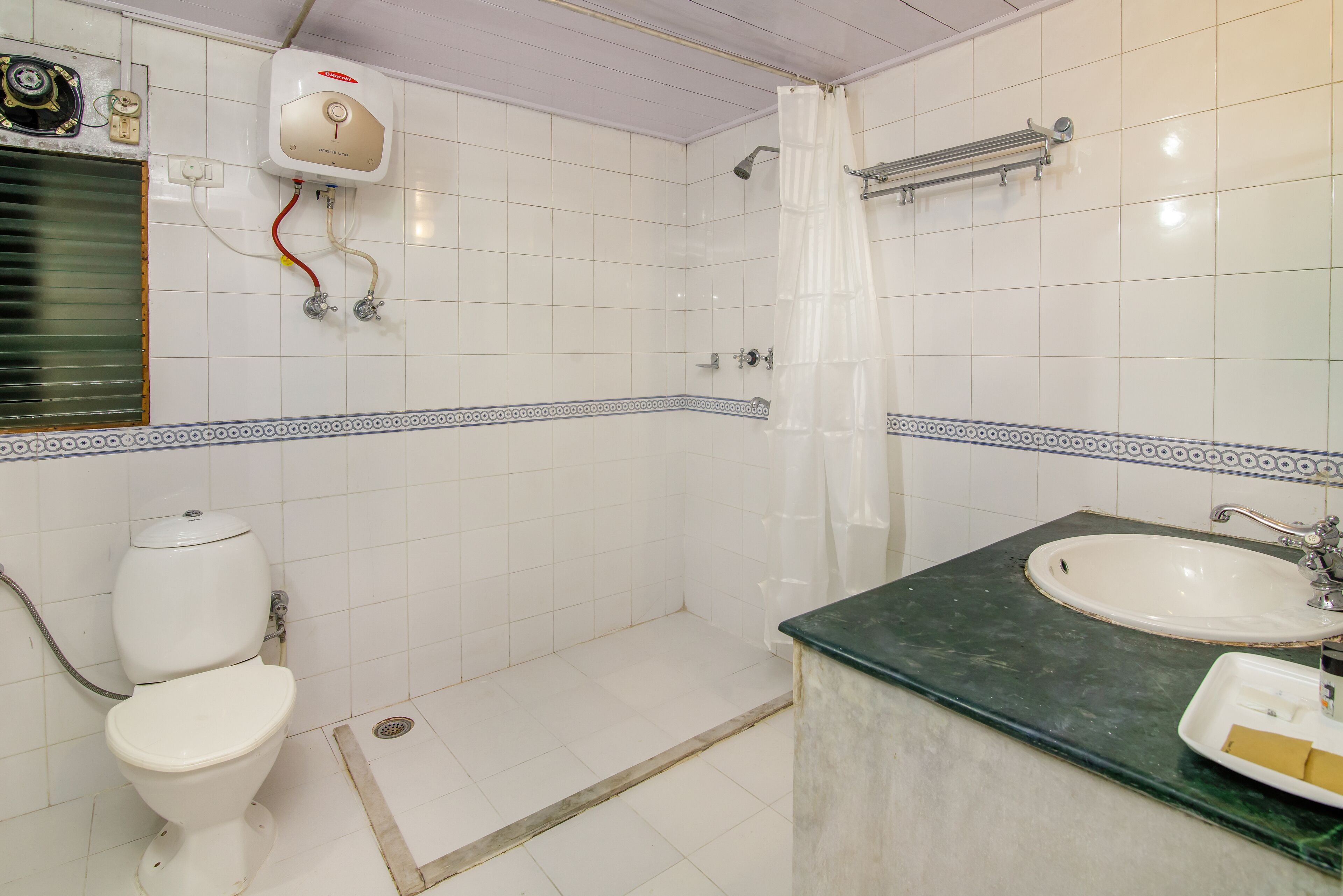 Een badkamer met toilet, douche en wastafel.