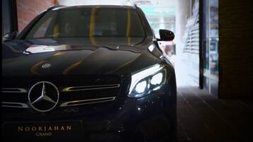 A black Mercedes-Benz car with the text "NOORJAHAN GRAND" on the front.