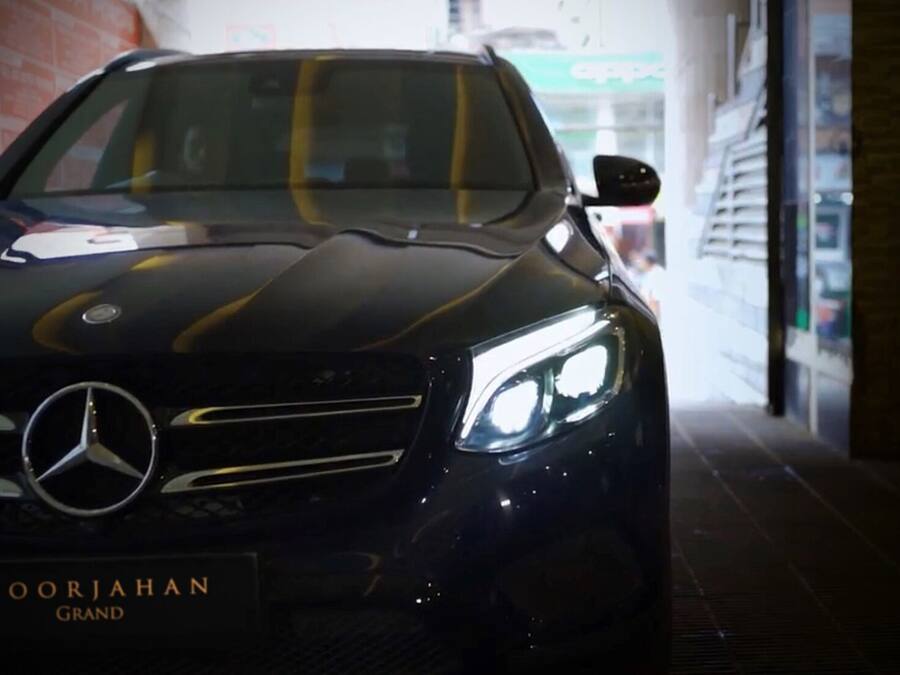A black Mercedes-Benz car with the text "NOORJAHAN GRAND" on the front.