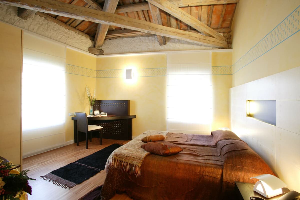 Un dormitorio con una cama, un escritorio y una silla.