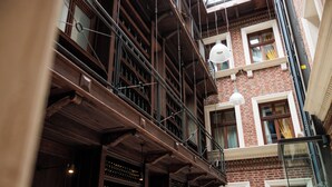 A multi-story building with exposed brickwork, wooden beams, and a series of balconies with railings. - Palazzo Rosso Old Town (Poznan)