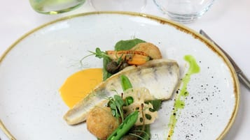 A plate of food with a bottle of Glen Carlou South African Pinot Noir 2020.