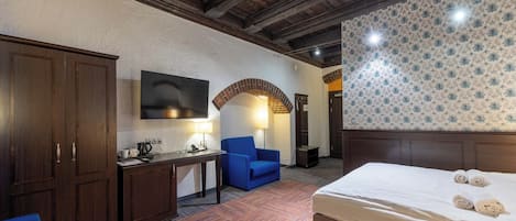 Una habitación de hotel con cama, escritorio, silla y armario.