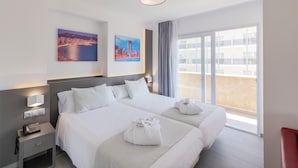 A hotel room with a large bed, a bedside table with a phone, and two paintings on the wall. - Hotel Los Alamos (Benidorm)