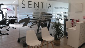 A wellness center with exercise equipment, a reception desk, and a glass wall with the name 'SENTIA'. - Hotel Los Alamos (Benidorm)