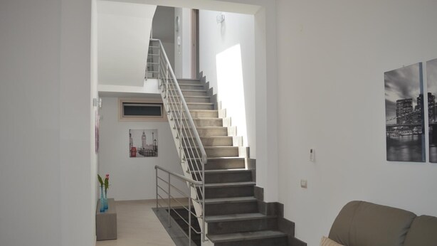 Una sala de estar moderna con una escalera que lleva a un nivel superior.
