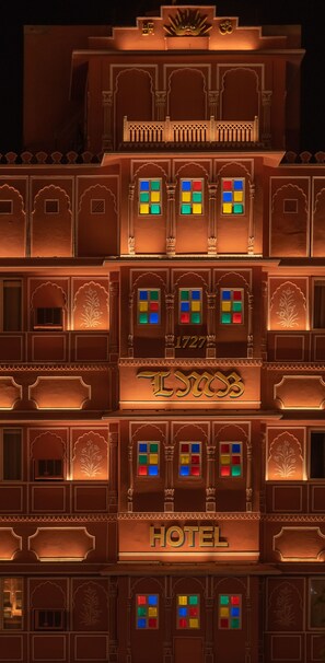 A multi-story building with traditional architectural elements, including arched windows and decorative motifs. The building has a sign that reads "HOTEL" and a number "1727" above it. - LMB Hotel (Jaipur)