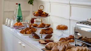 A buffet with various pastries, bread, and a toaster. - L'Hôtel Particulier Béziers (Béziers)