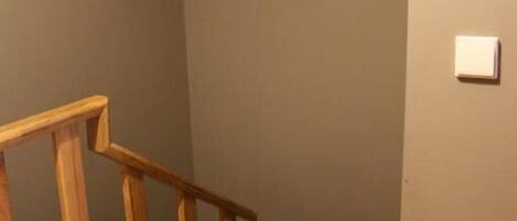 A wooden staircase with a handrail leading to a landing.