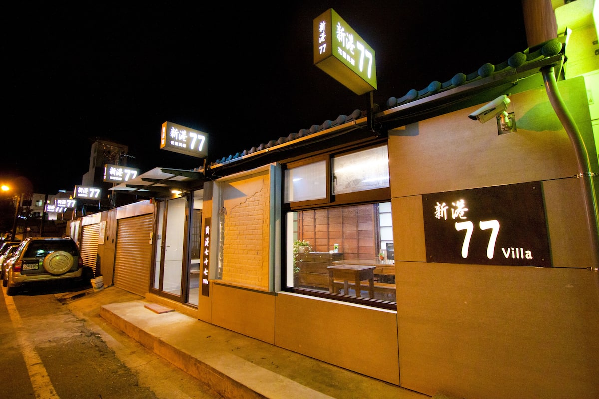 A building with a sign reading "77 villa" and a number "77" on the facade.