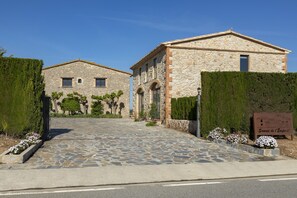 Un bâtiment en pierre avec une entrée pavée et une enseigne.