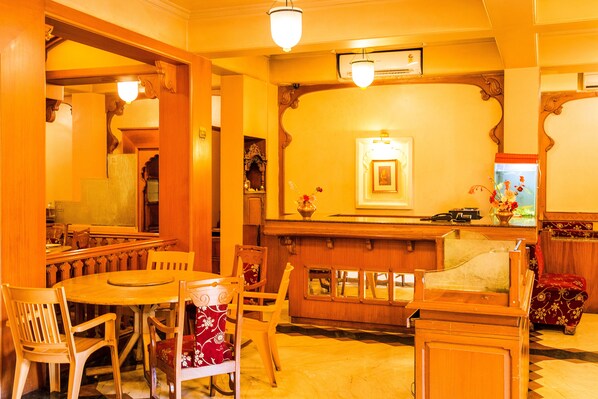 A traditional interior with wooden furniture, a reception desk, and a mirror. - FabHotel Rajwada Baner (Pune)