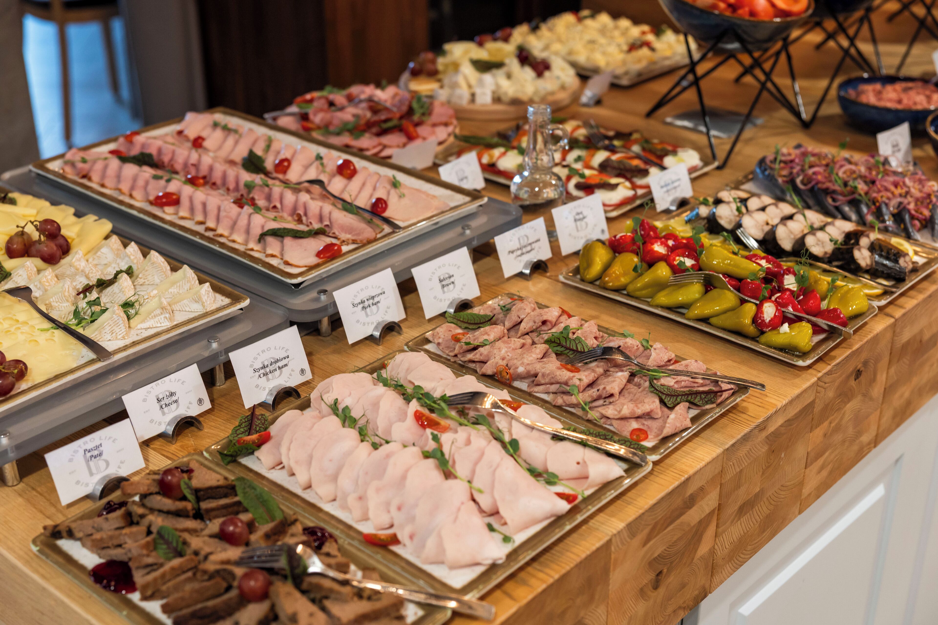 Un buffet proposant une variété de plats, chacun étant accompagné d’une étiquette indiquant son nom.
