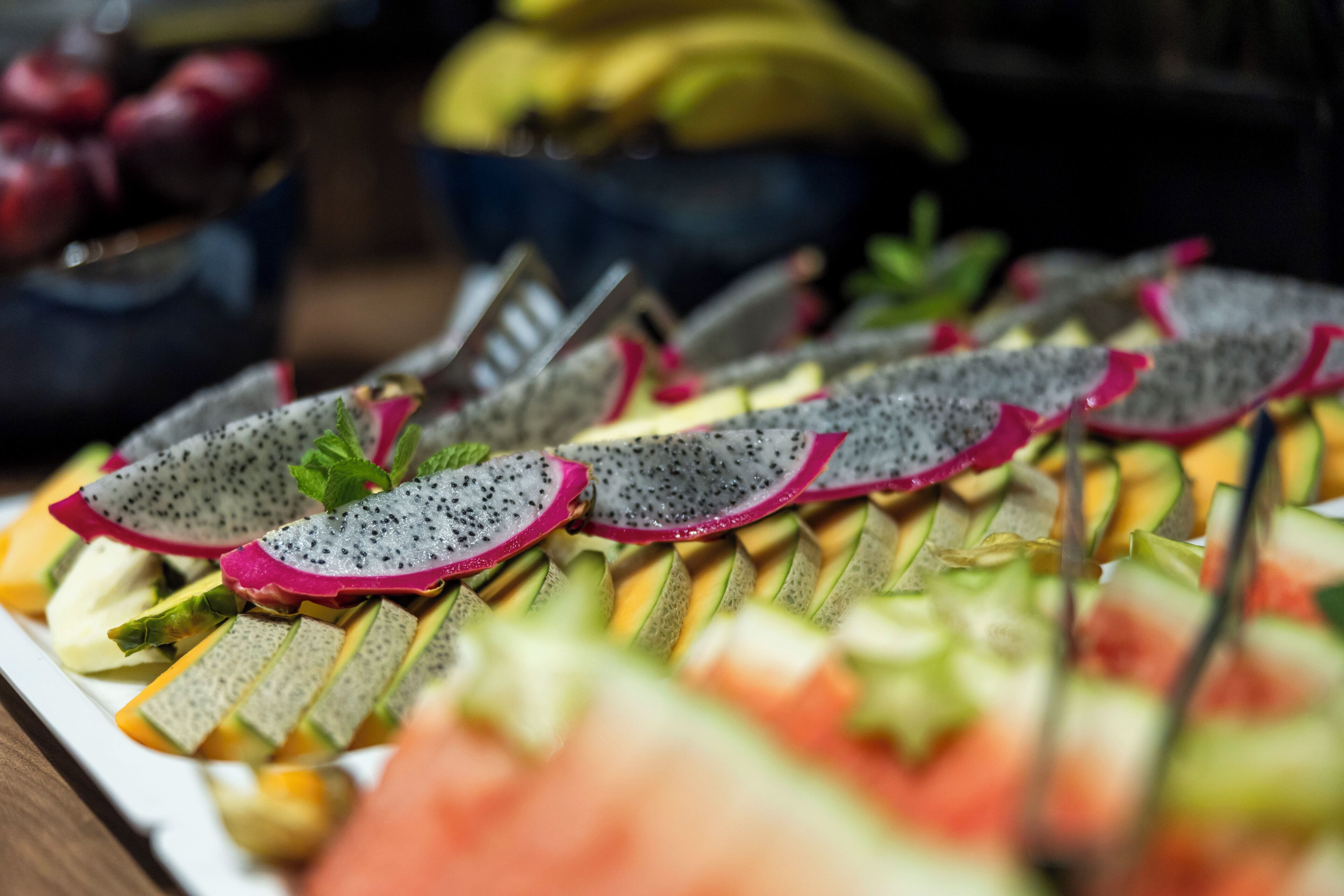 Een fruitschaal met pitahaya, kiwi en meloen.