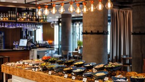 Un bufé con diferentes opciones de comida y una zona de bar al fondo.
