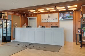 Un comptoir d’accueil avec une enseigne indiquant « GRANO’LIFE », un intérieur en bois et une vitrine.
