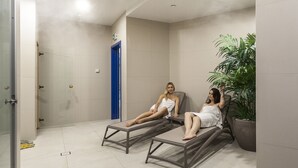 Dos tumbonas en una habitación con suelo de baldosas y una planta en maceta.