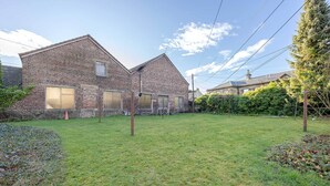 A brick building with a grassy yard, a tree, and a hedge. - Carmel Apartments Queen Street Residence (Falkirk)