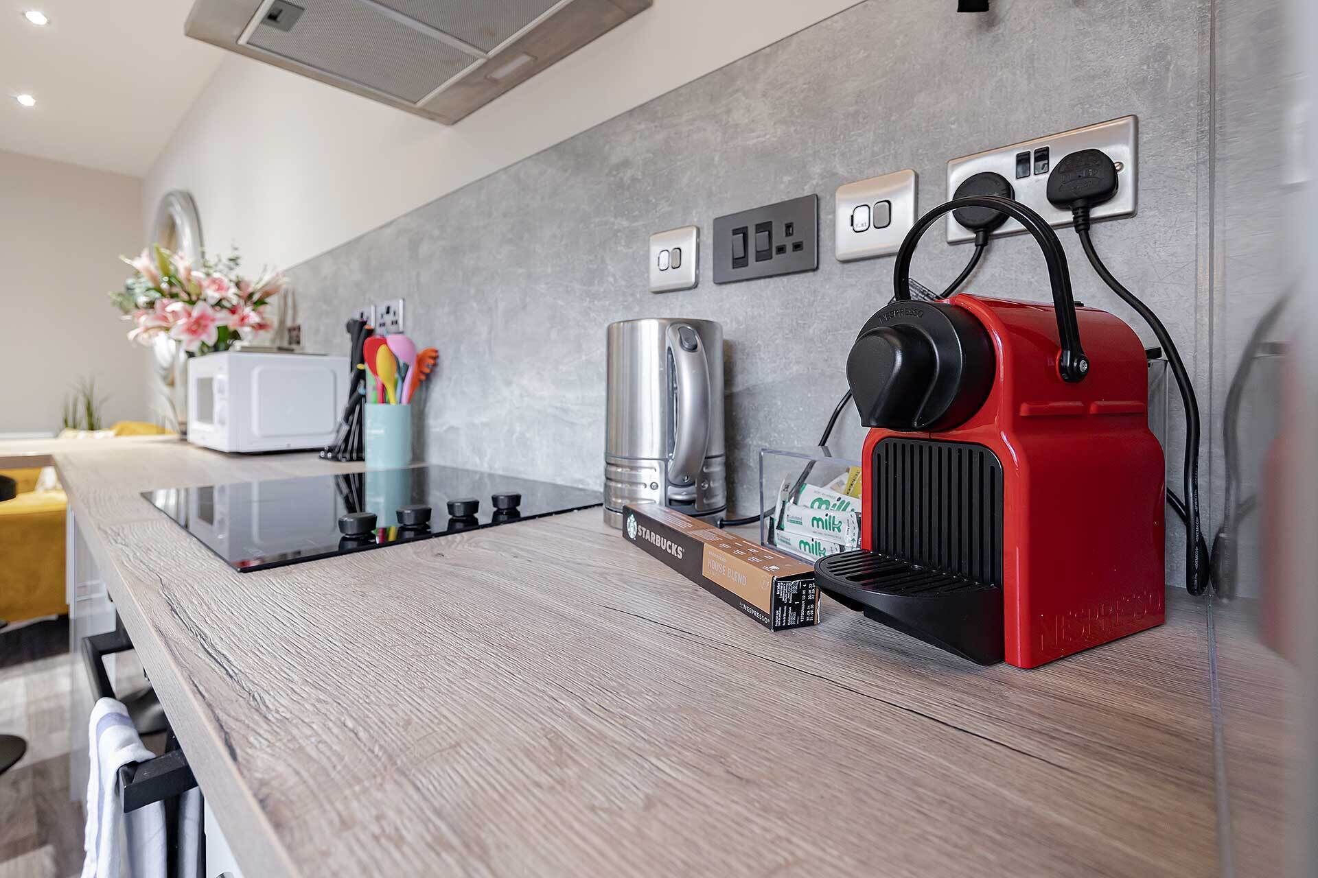 Eine moderne Küche mit integrierter Espressomaschine, Wasserkocher und Mikrowelle.