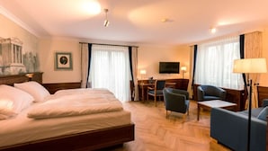 Habitación de hotel con una cama grande, un escritorio, una silla, un sofá y una televisi ón.
