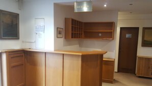 A reception area with a wooden reception desk, a reception sign, a framed picture on the wall, and a door labeled "RECEPTION". - Hotel Alt Steinbach (Steinbach)