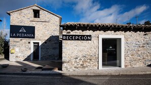 A stone building with a reception area and a sign reading "LA PEDANTA". - Camping & Bungalows Ligüerre de Cinca (Abizanda)