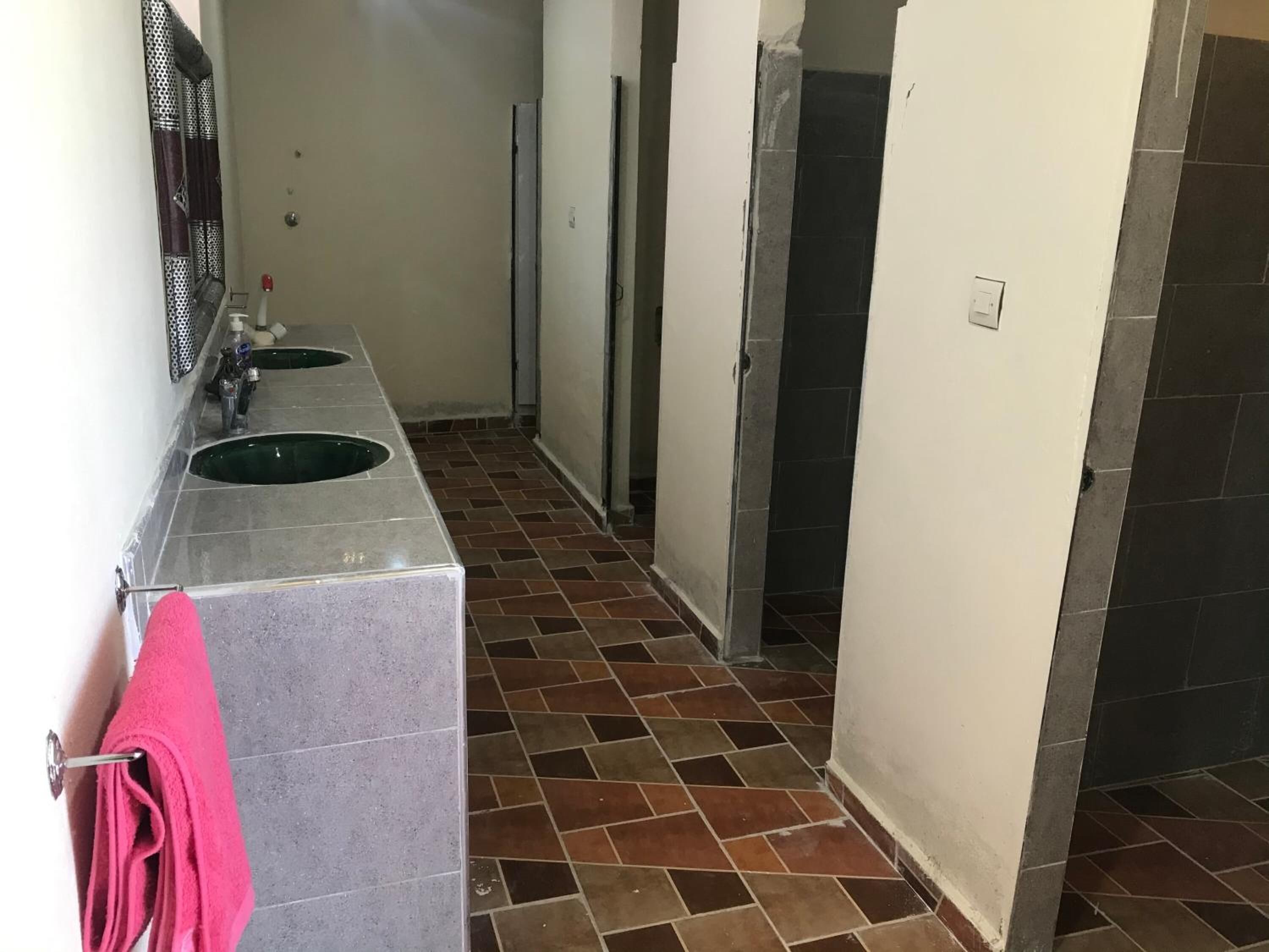 A bathroom with two sinks, a mirror, and a pink towel.