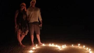 Two people standing in a circle of candles.