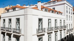 A white building with multiple balconies and a tiled roof.