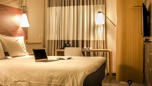 A hotel room with a bed, a desk, a laptop, a telephone, and a television. - ibis Guaiba (Guaiba)
