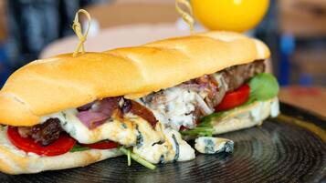 Un sándwich con un palillo encima, sobre un plato oscuro.