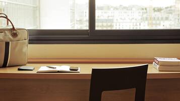Een bureau met een handtas, een boek, een pen en een smartphone.