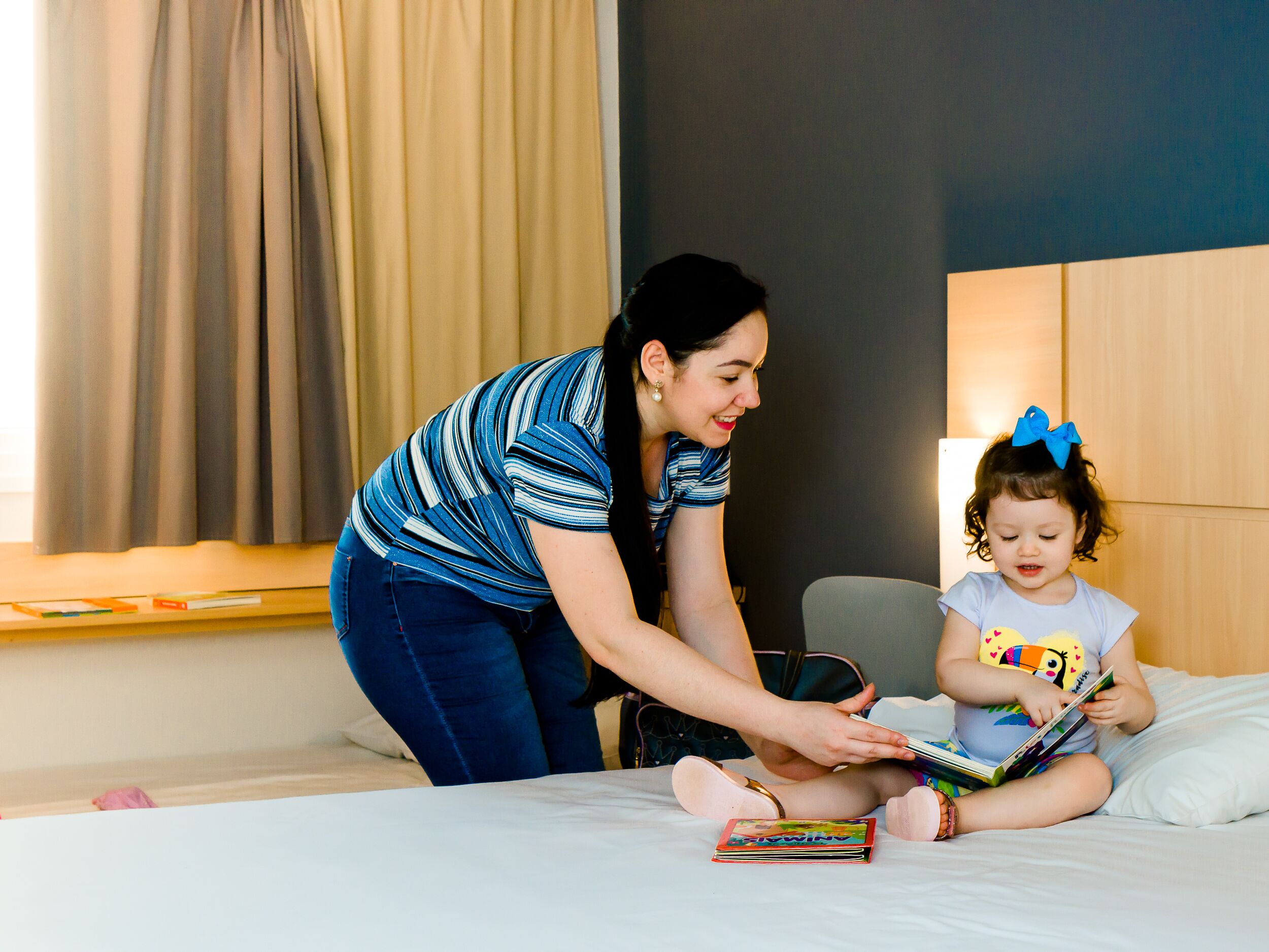 Uma mulher e uma criança na cama com um livro.