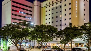 Un hotel de varios pisos con un llamativo letrero de 'ibis HOTEL' en la parte superior.