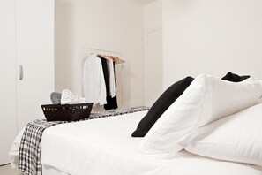 Relax in a serene space with a neatly made bed and stylish storage.