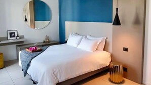A modern bedroom with a bed, a round mirror, a bedside table, and a round rug. - Palazzo Talenti 1907 (Trieste)