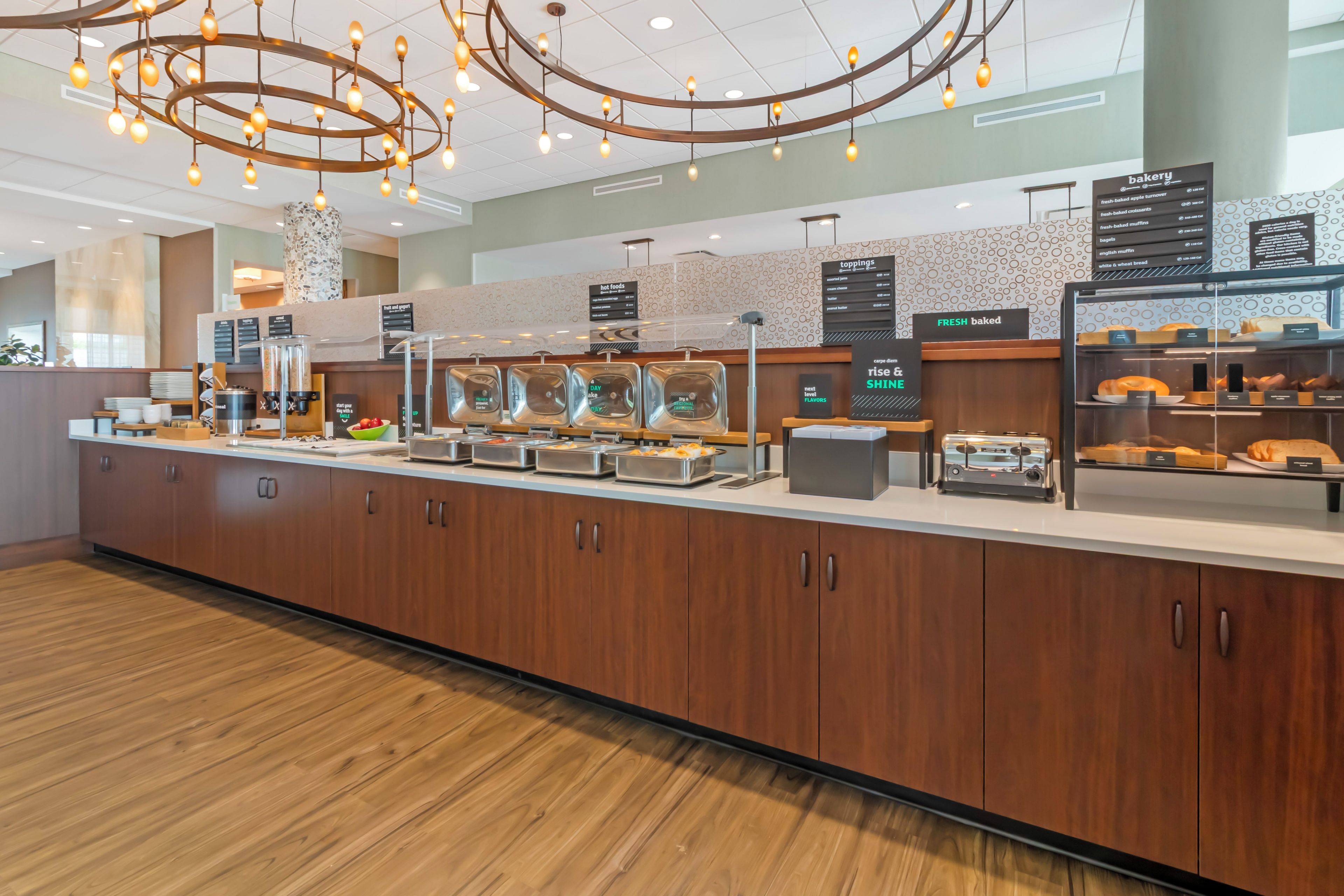 A buffet area with various food stations, including a section for fresh baked items and a display of bread.