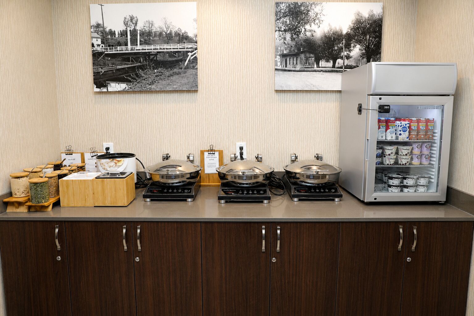 A kitchenette with a coffee machine, a food dispenser, and a refrigerator stocked with beverages.