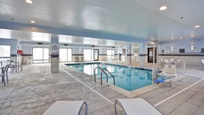 Eine Hotlellobby mit Schwimmbad, Sitzbereichen und einer Rezeption.