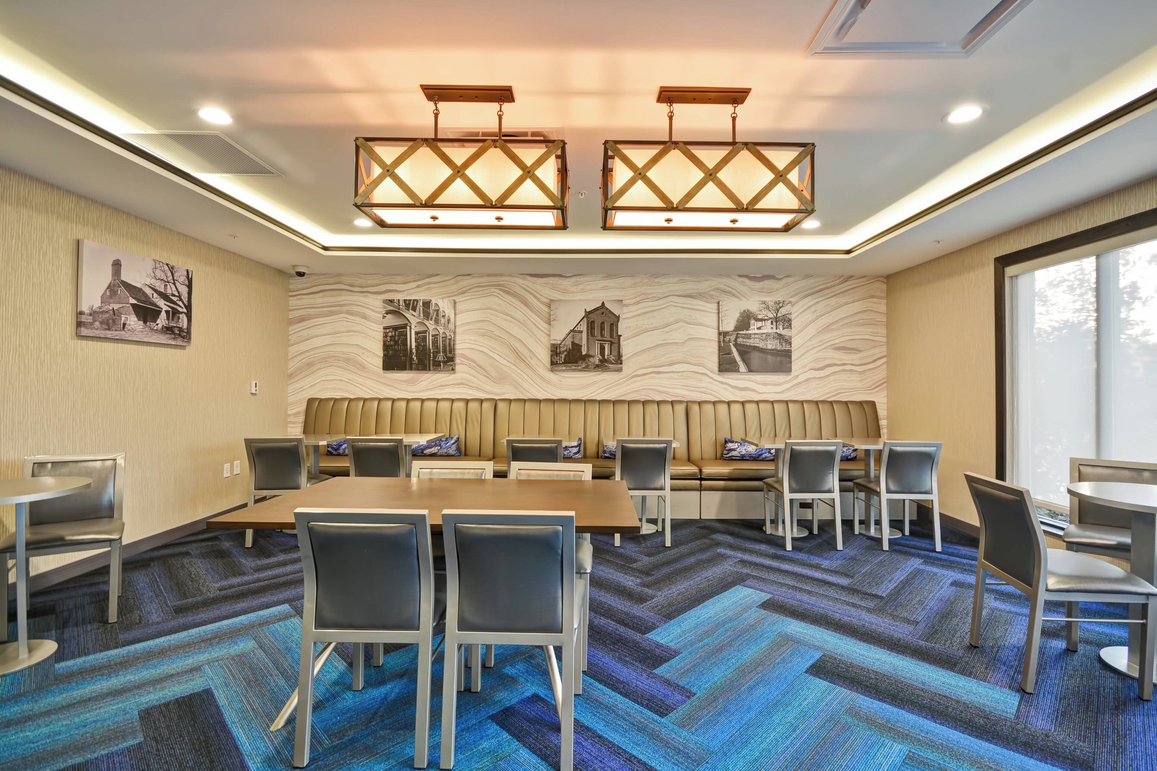 A conference room with a long table, chairs, a sofa, and a patterned wall.