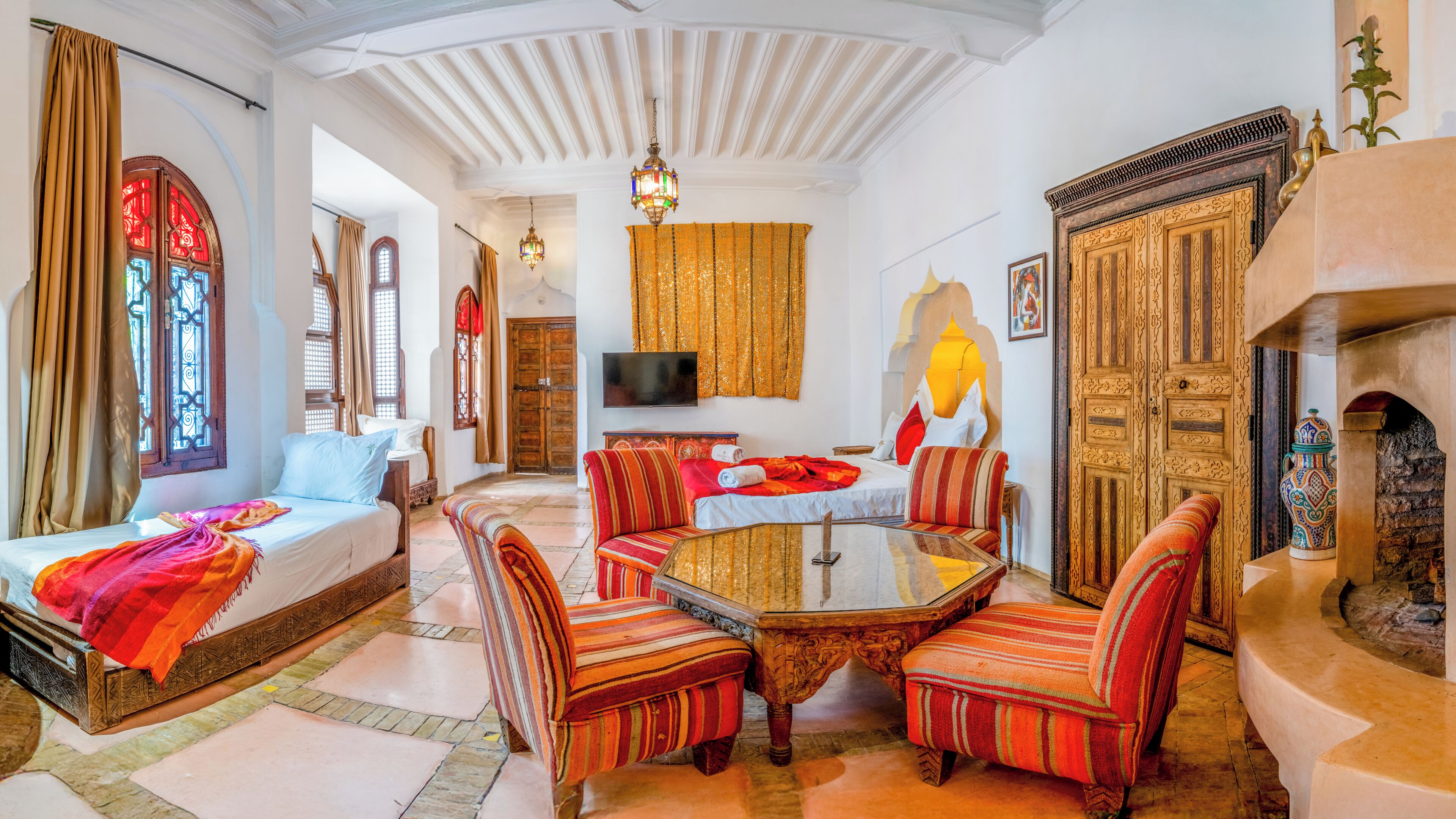 A traditional room with a sofa, armchairs, a coffee table, and a television.