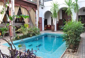 A courtyard with a swimming pool, surrounded by traditional architecture and potted plants. - Riad Ghali & SPA (Marrakech)
