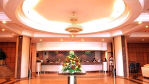 A lobby with a reception desk, a chandelier, and a floral arrangement. - Dynasty Hotel Miri (Miri)