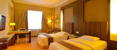 An exclusive deluxe twin room with two beds, a desk, a chair, and a TV.